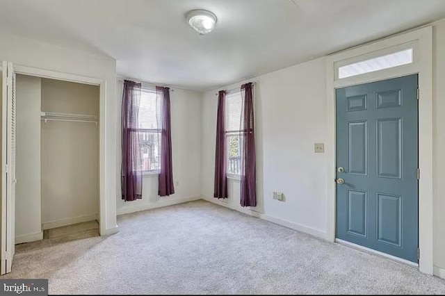 unfurnished bedroom with light colored carpet and a closet