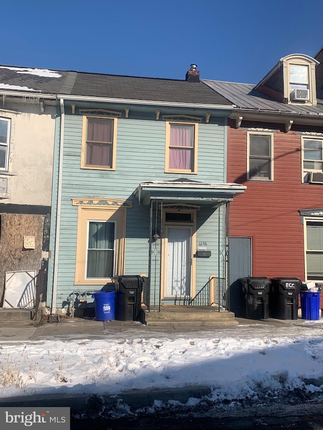 snow covered house featuring cooling unit