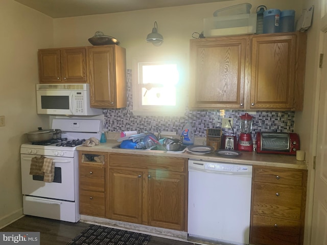 kitchen with sink, white appliances, and decorative backsplash