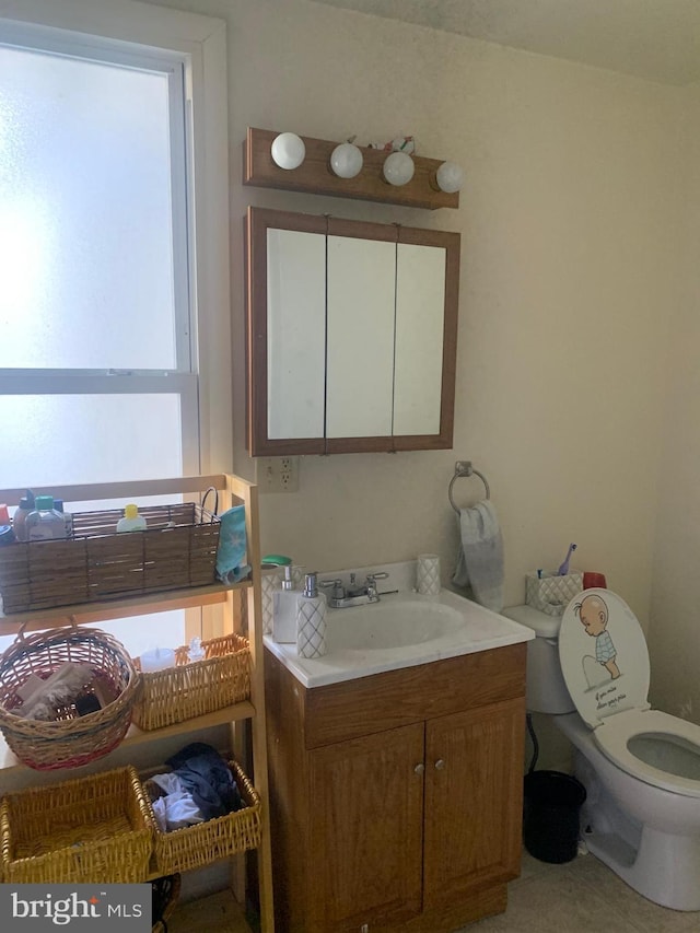 bathroom featuring vanity, toilet, and a healthy amount of sunlight