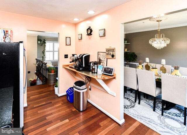 kitchen featuring pendant lighting, dark wood-type flooring, stainless steel refrigerator, and a chandelier