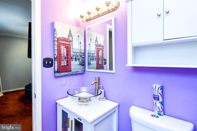 bathroom with vanity, ornamental molding, and toilet