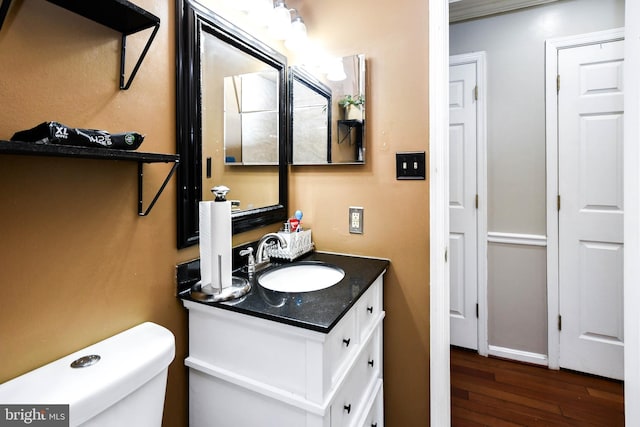 bathroom with vanity, toilet, and hardwood / wood-style floors