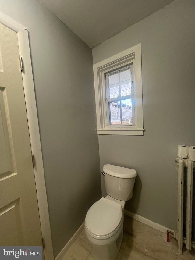 bathroom with radiator heating unit and toilet