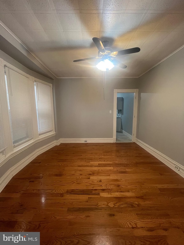 empty room featuring hardwood / wood-style flooring, ornamental molding, and ceiling fan