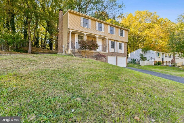 view of front of property with a garage, a front yard, and covered porch