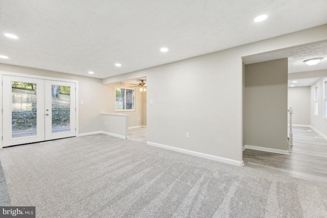 carpeted empty room with french doors and a textured ceiling