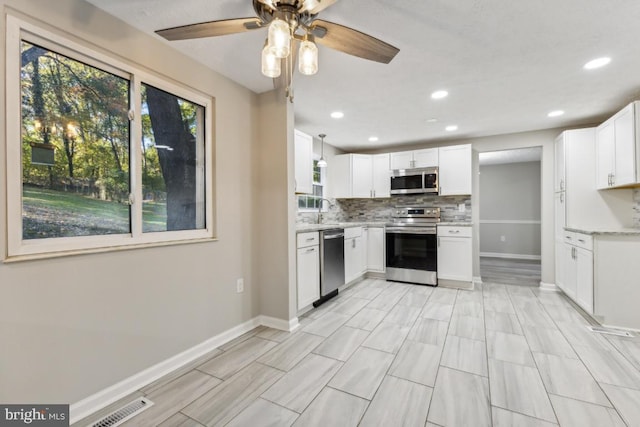 kitchen featuring tasteful backsplash, appliances with stainless steel finishes, sink, and white cabinets