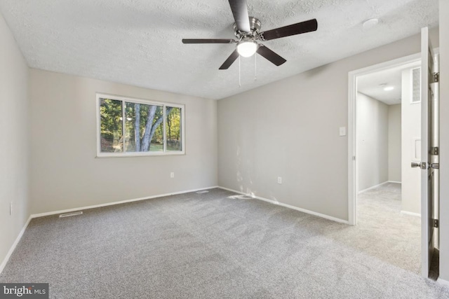 carpeted spare room with a textured ceiling