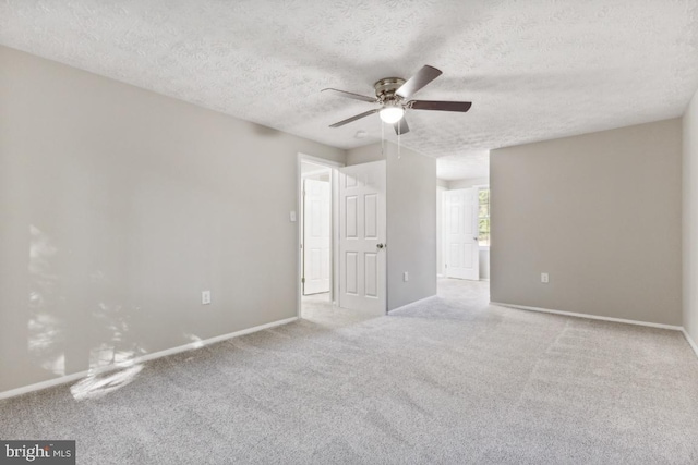 unfurnished room with a textured ceiling, light colored carpet, and ceiling fan