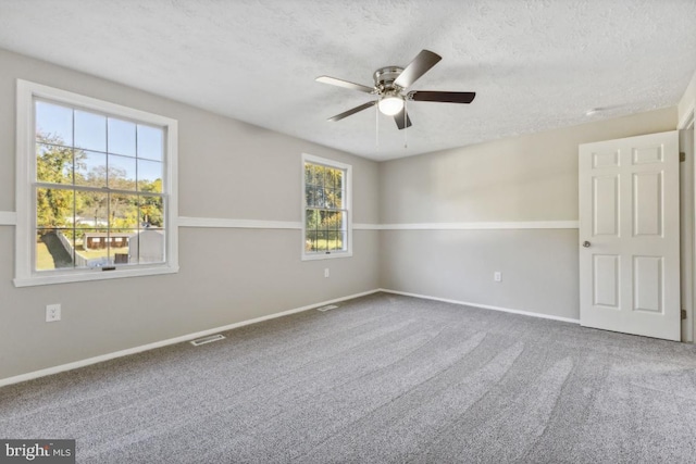 carpeted empty room featuring ceiling fan and a textured ceiling