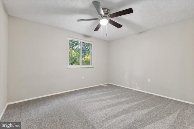 carpeted empty room featuring ceiling fan and a textured ceiling