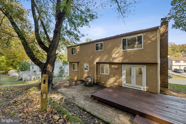 rear view of property featuring cooling unit and a deck