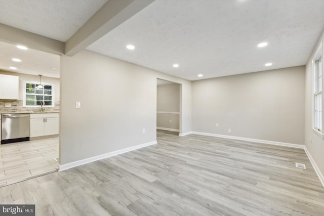 unfurnished living room with sink and light hardwood / wood-style floors