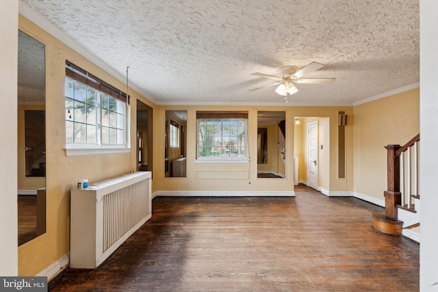 interior space featuring radiator, wood-type flooring, ornamental molding, and a textured ceiling