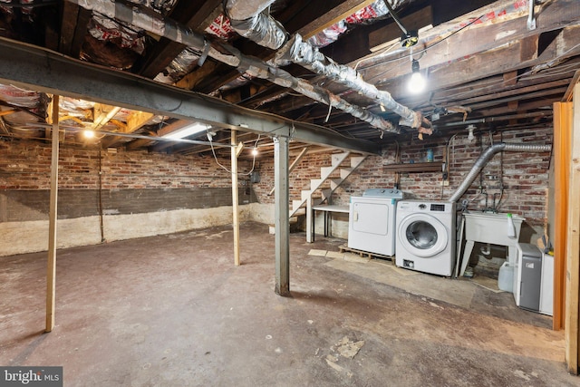 basement with washer and dryer and brick wall