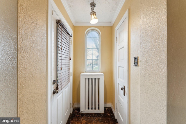 entryway with crown molding, radiator heating unit, and a textured ceiling