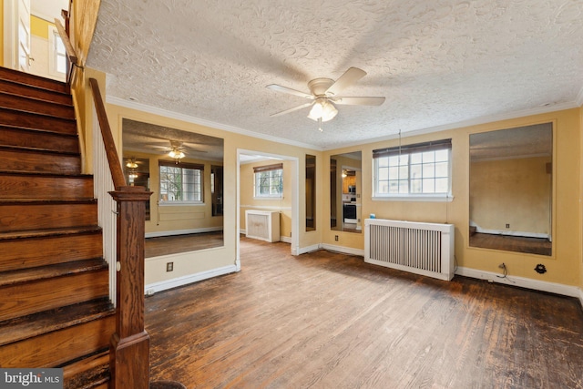 unfurnished living room featuring radiator, hardwood / wood-style flooring, ceiling fan, crown molding, and a textured ceiling