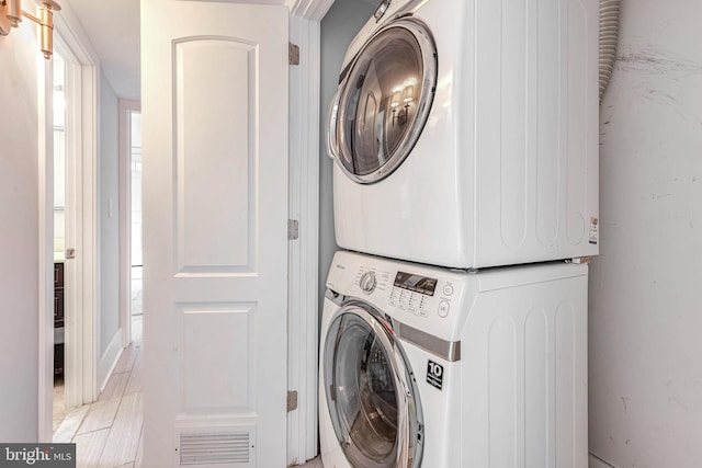 washroom featuring stacked washing maching and dryer