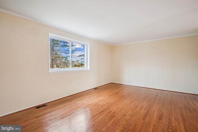 spare room featuring crown molding and hardwood / wood-style floors