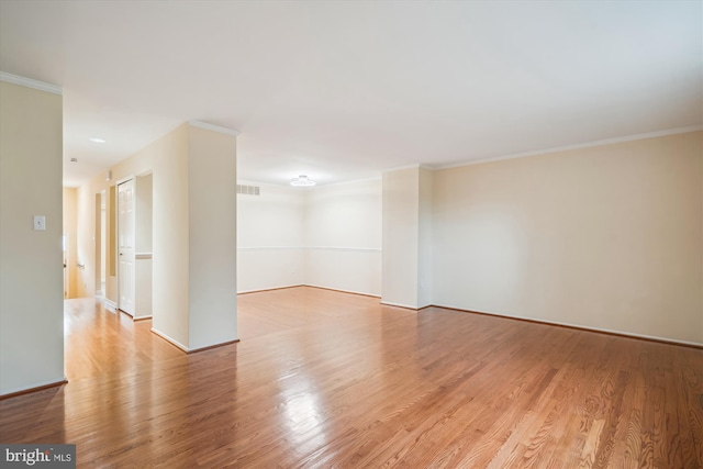 empty room featuring ornamental molding and light hardwood / wood-style floors