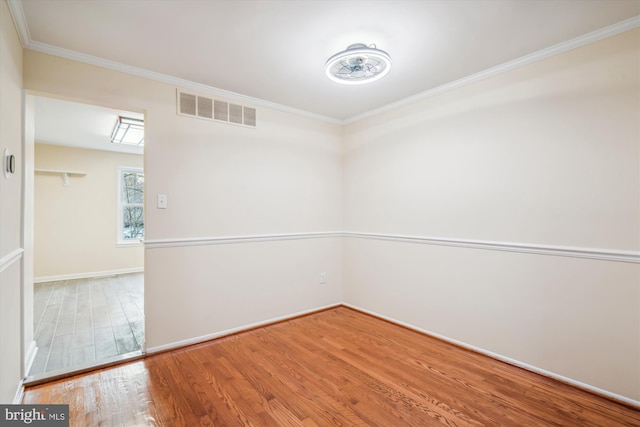 empty room featuring hardwood / wood-style flooring and crown molding