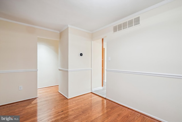 spare room featuring hardwood / wood-style floors and crown molding