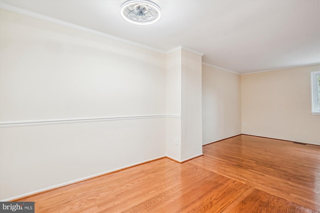 empty room featuring hardwood / wood-style flooring and ornamental molding