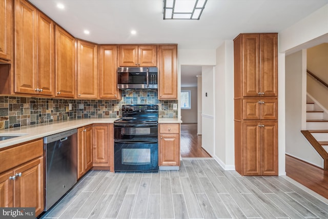 kitchen featuring tasteful backsplash, light hardwood / wood-style floors, and appliances with stainless steel finishes