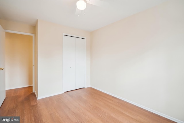 unfurnished bedroom featuring ceiling fan, light wood-type flooring, and a closet