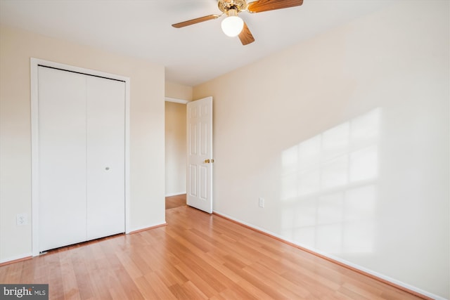 unfurnished bedroom featuring hardwood / wood-style flooring, ceiling fan, and a closet