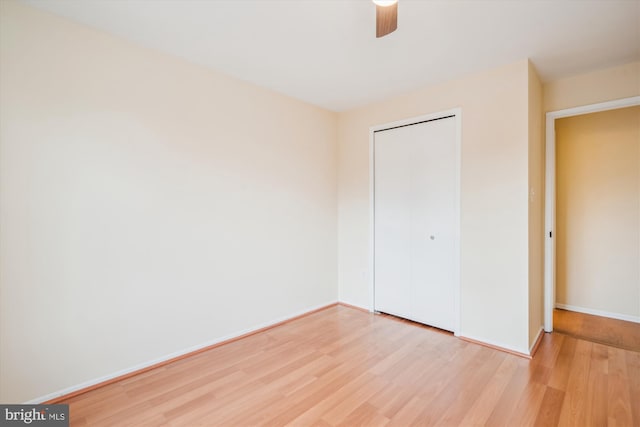 unfurnished bedroom with ceiling fan, wood-type flooring, and a closet