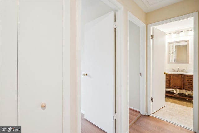 corridor with sink and hardwood / wood-style floors