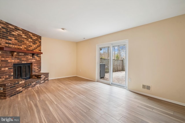 unfurnished living room featuring light wood-type flooring and a fireplace