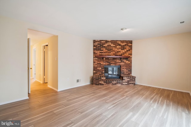 unfurnished living room featuring light hardwood / wood-style floors and a wood stove