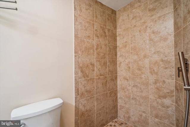 bathroom featuring toilet and a tile shower