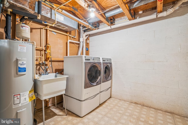 laundry area featuring washer and dryer, sink, and electric water heater