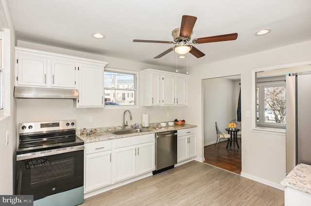 kitchen featuring stainless steel appliances, white cabinetry, plenty of natural light, and sink