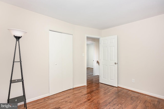 unfurnished bedroom with hardwood / wood-style flooring and a closet