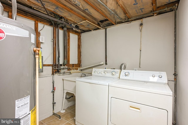 washroom with washer and dryer, light tile patterned floors, and water heater