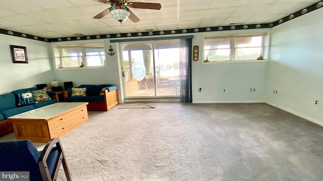 unfurnished living room featuring light colored carpet, a drop ceiling, and ceiling fan