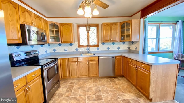 kitchen with sink, tasteful backsplash, kitchen peninsula, pendant lighting, and stainless steel appliances