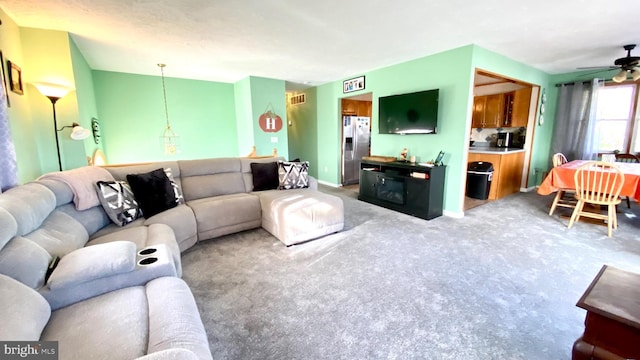 carpeted living room with ceiling fan