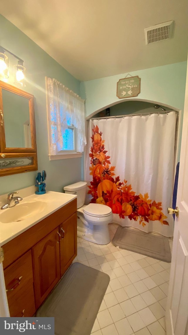 bathroom with a shower with curtain, tile patterned floors, vanity, and toilet