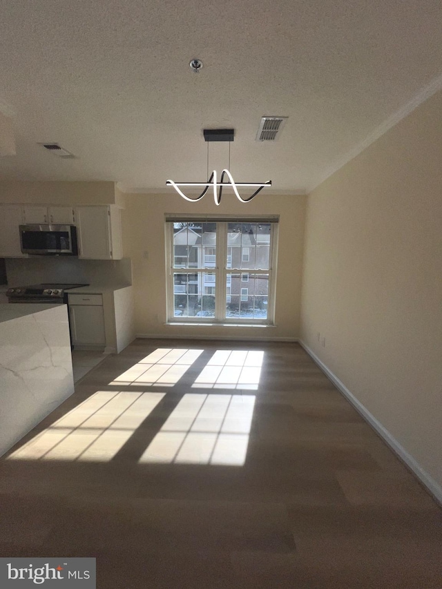 unfurnished dining area featuring a textured ceiling and an inviting chandelier