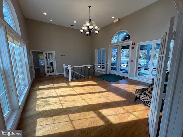 entrance foyer with french doors, light hardwood / wood-style floors, and high vaulted ceiling