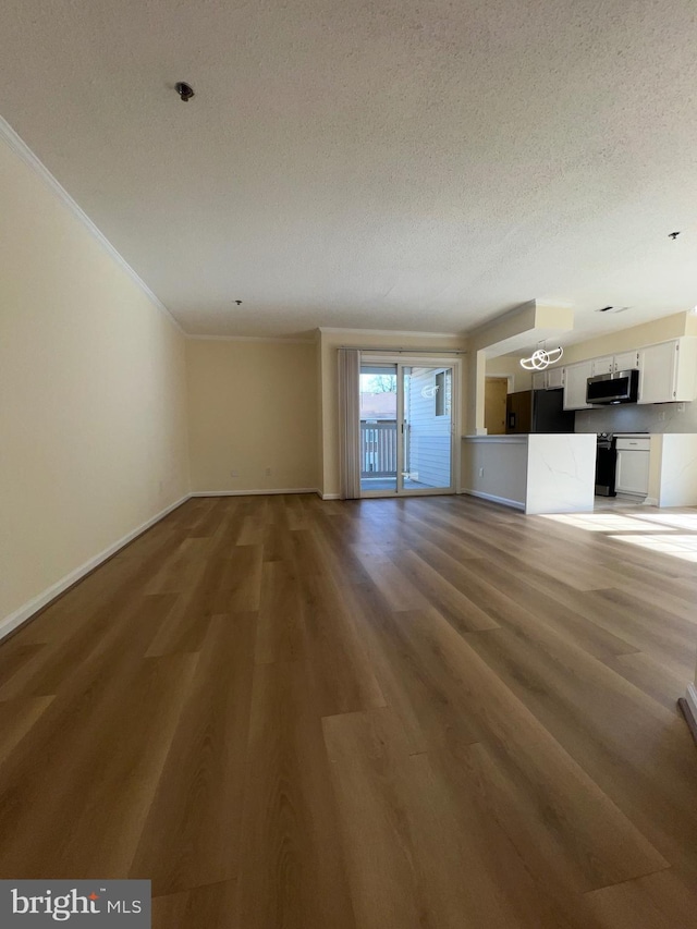 unfurnished living room with crown molding, hardwood / wood-style floors, and a textured ceiling