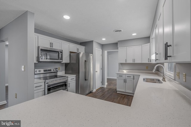 kitchen with white cabinetry, sink, a textured ceiling, and appliances with stainless steel finishes