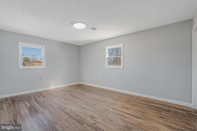 spare room with wood-type flooring and a textured ceiling