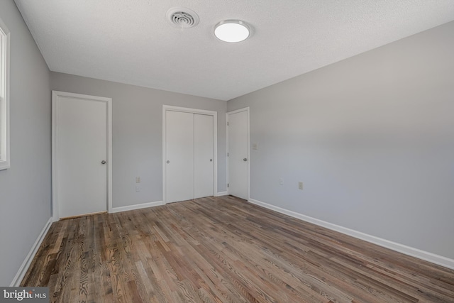 unfurnished bedroom featuring hardwood / wood-style flooring and a textured ceiling